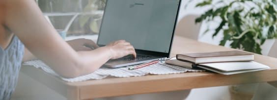 a woman sitting by a desk with a computer on it
