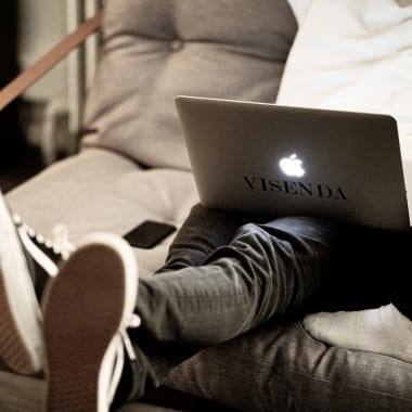 Person sitting on the coach with their Macbook